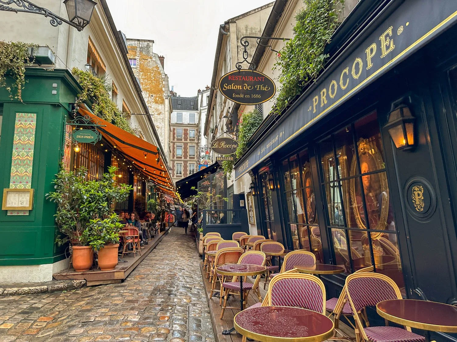 Cozy Paris café-lined alley with outdoor dining, a romantic destination in Paris for couples seeking charming city experiences.