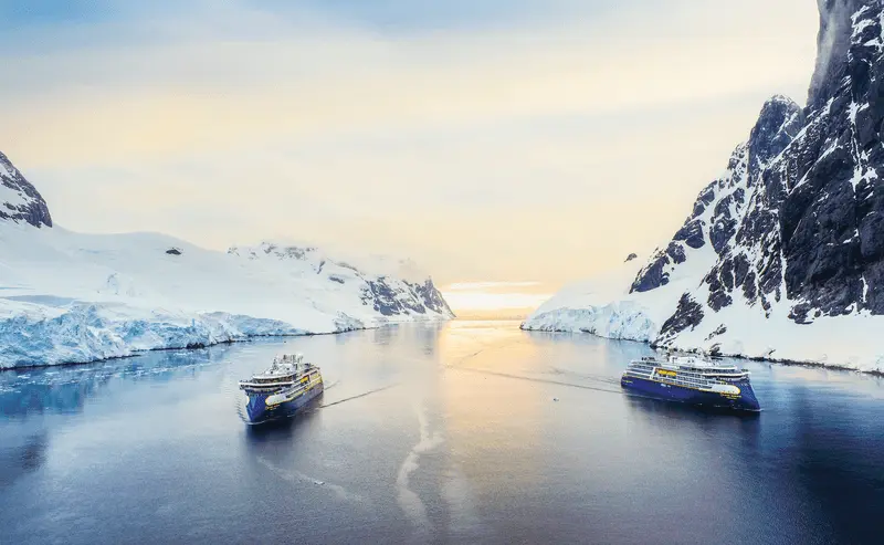 Lindblad expedition ship anchored in Antarctica during a guided polar cruise arranged by Paradise and Pixie Dust Travel Agency.