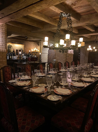 Wine cellar dinner at Sea Island Georgia with candlelit table, wood beam ceilings, and upscale fine dining experience.