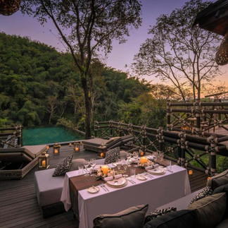 Private luxury dining experience overlooking tropical landscape at sunset, highlighting how a travel agent can plan personalized, stress-free romantic getaways.