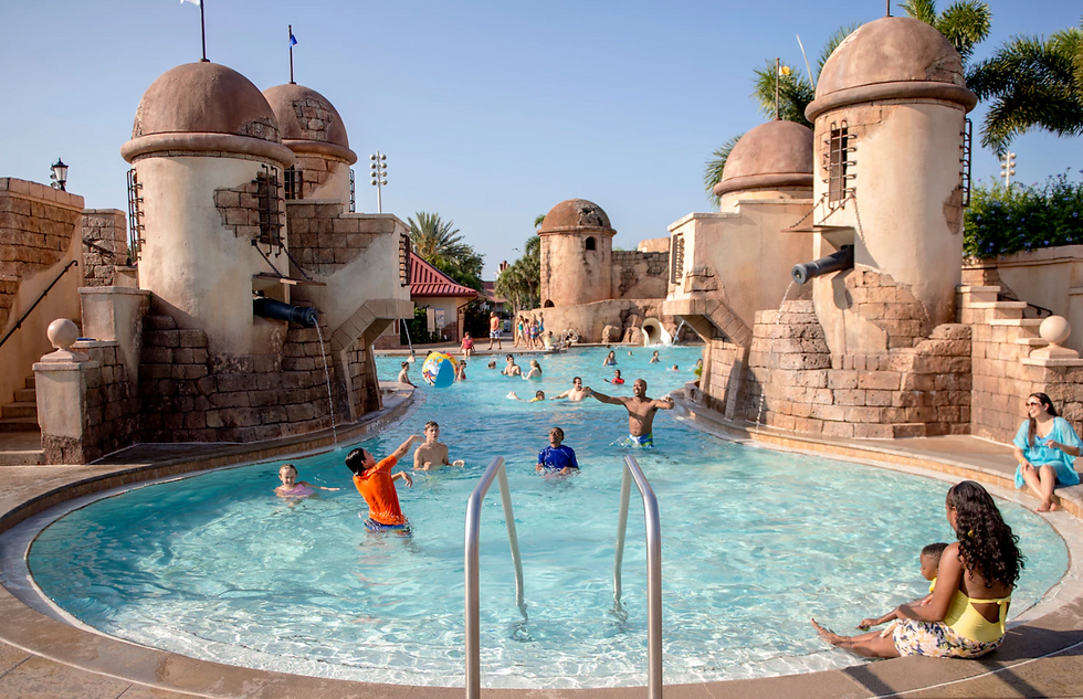 Families enjoying a pirate-themed swimming pool with water features at a Disney resort in Florida.