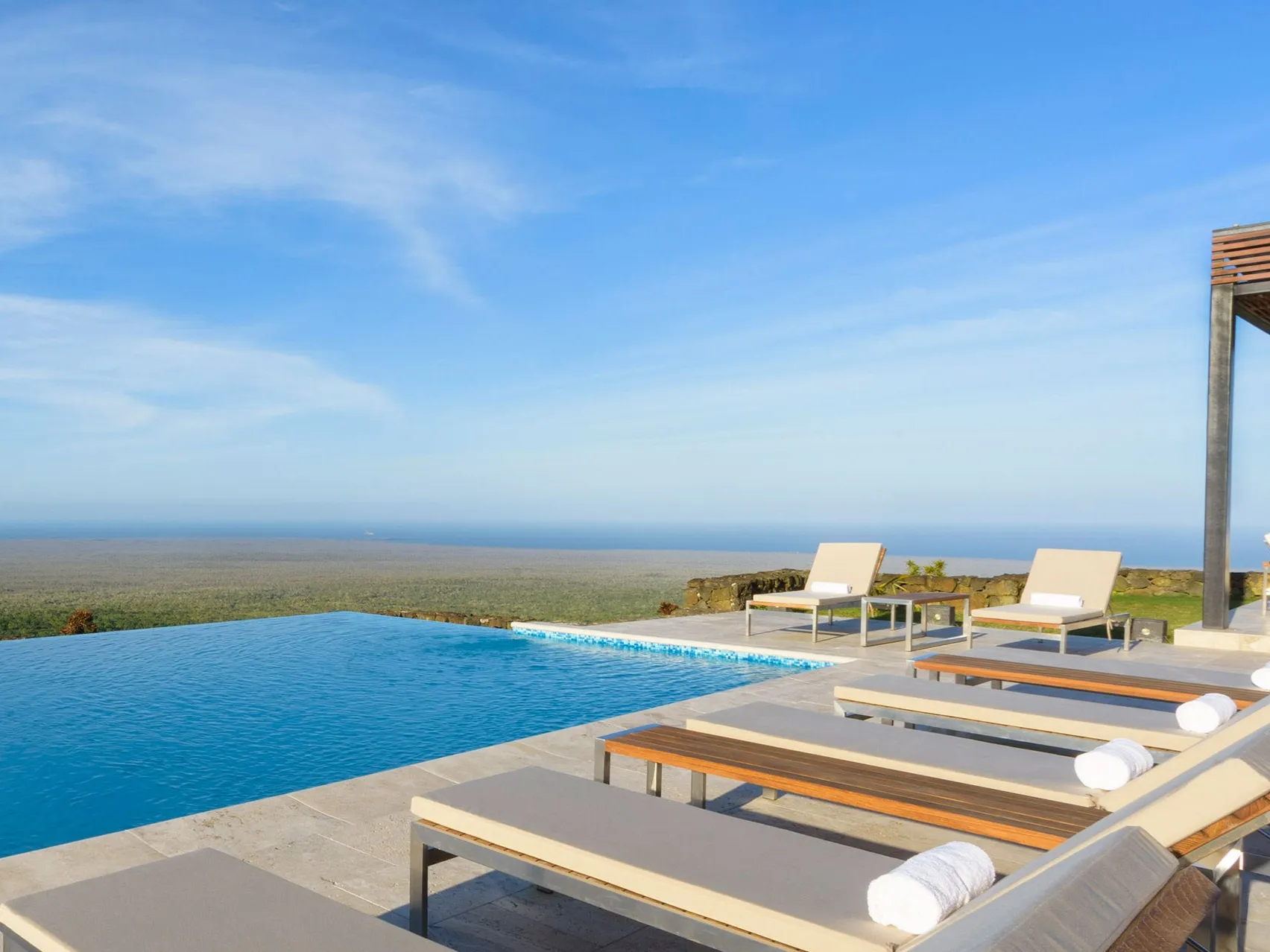 Oceanfront infinity pool at a luxury beach resort with panoramic coastal views and peaceful vacation atmosphere.