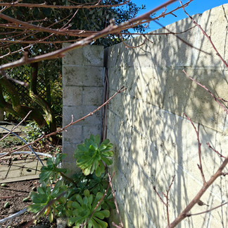 Concrete block wall with visible cracking and deterioration before replacement with a timber and Sma