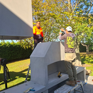 Contractors guiding chimney into place on Flare outdoor fireplaces unit in Hastings