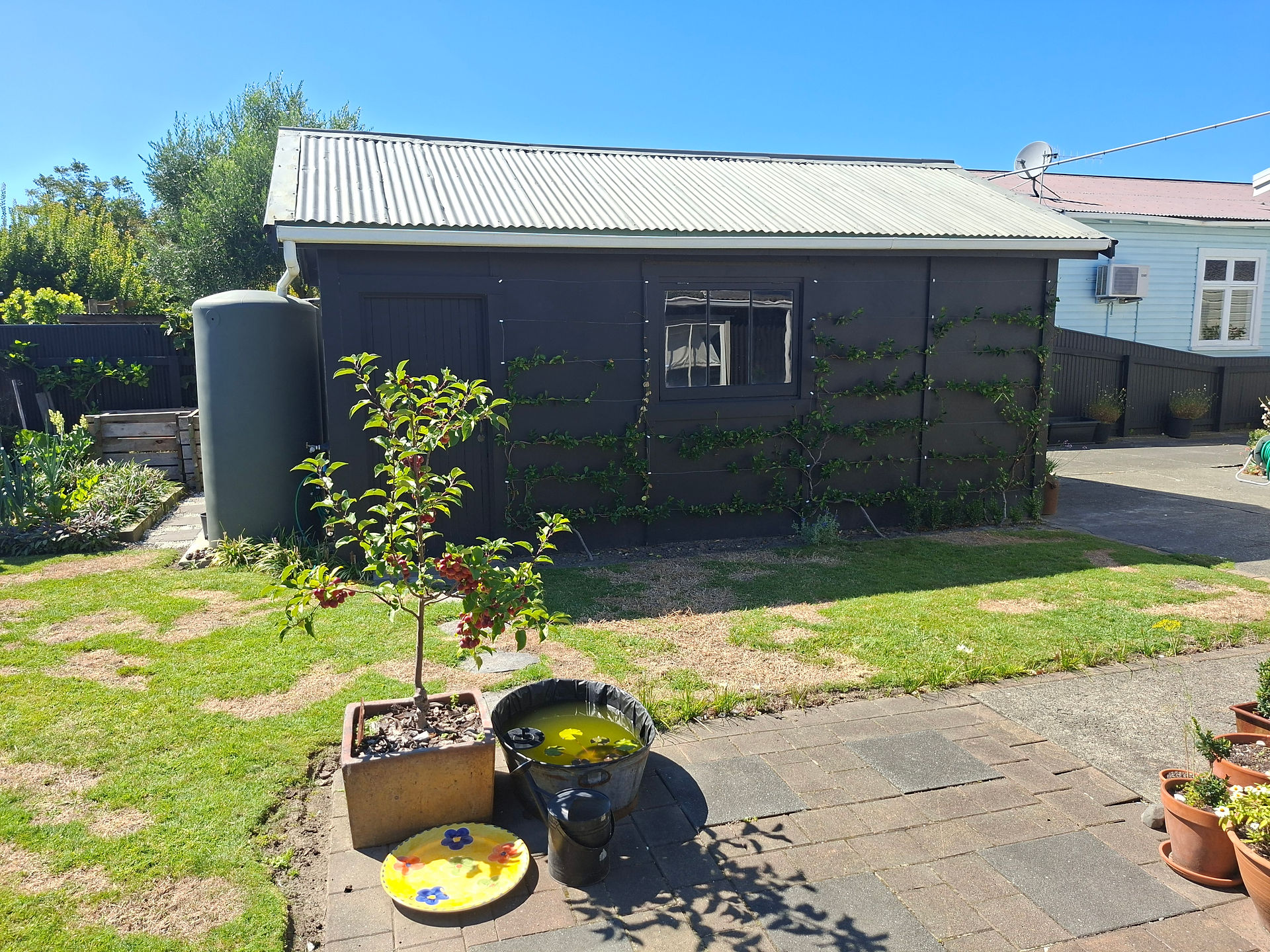 Existing outdoor living space and garage area before construction of new paving, pond feature and co