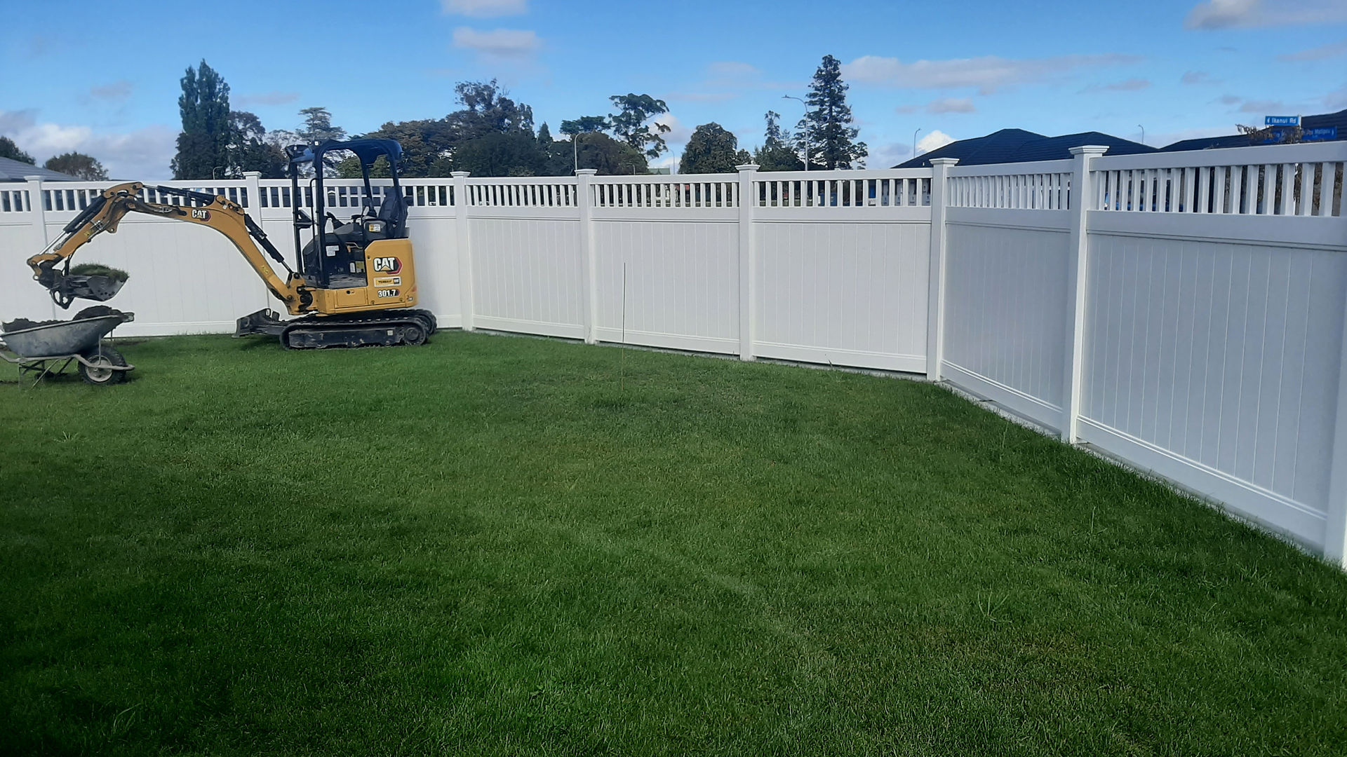 Decorative top PVC fence panels installed along backyard boundary in Hastings