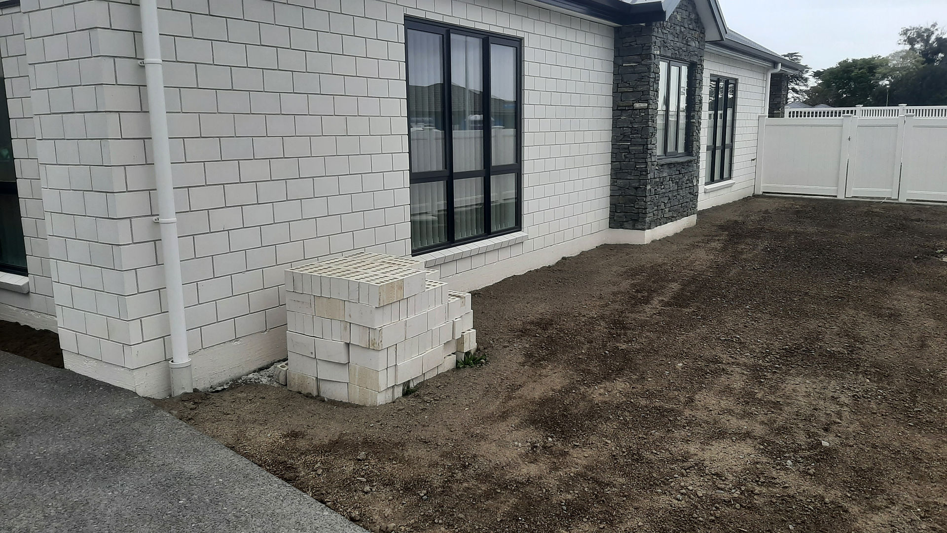 PVC fence installation beside new home exterior showing completed panel alignment in Hastings