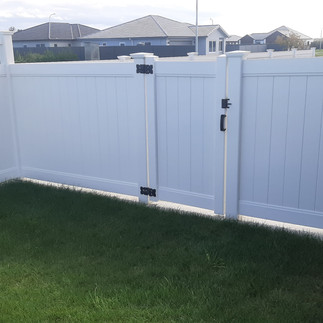 Close-up of PVC fence gate and latch installed for side access in Hastings