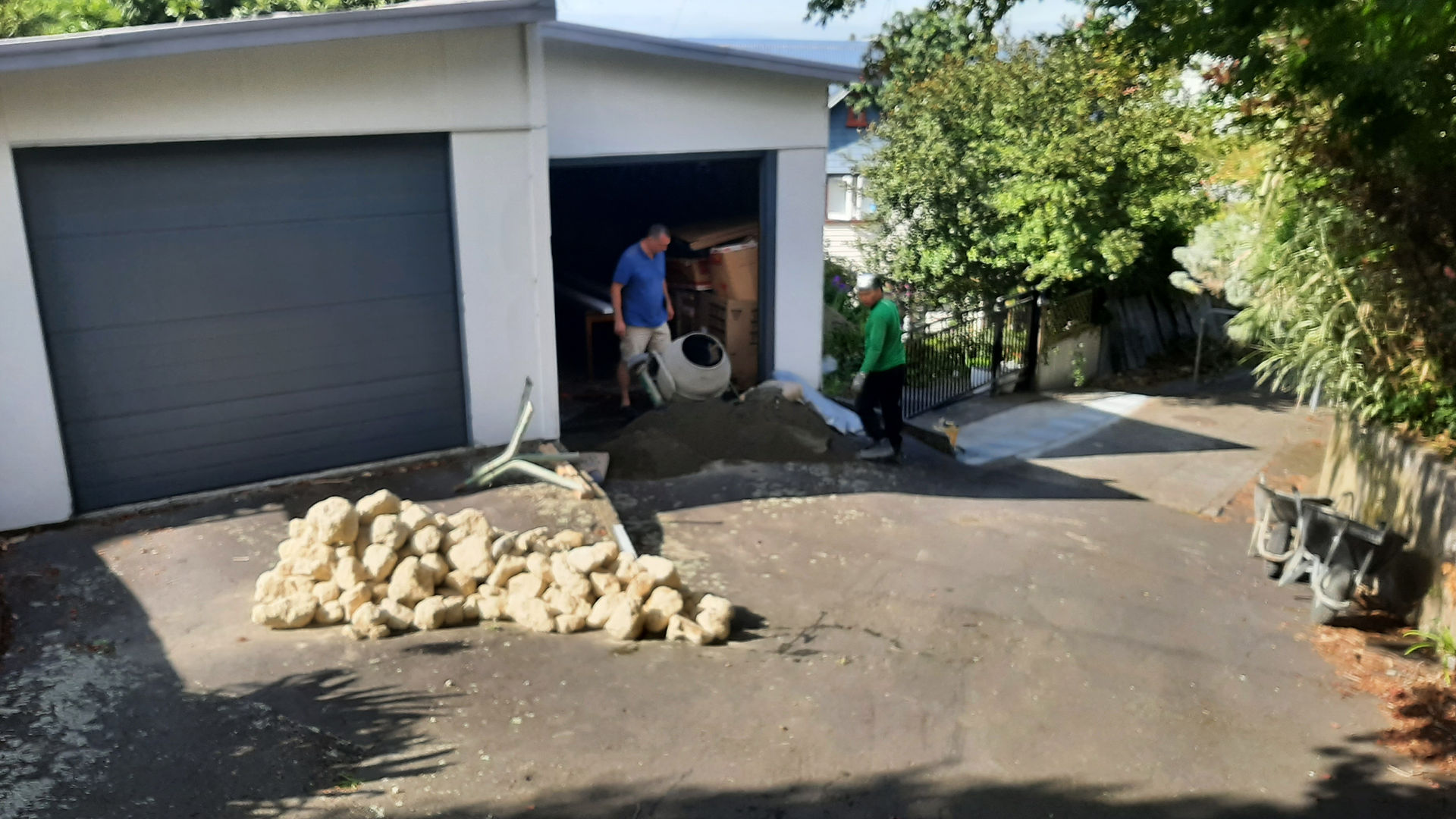 Contractors assembling natural stone retaining wall in Hastings driveway