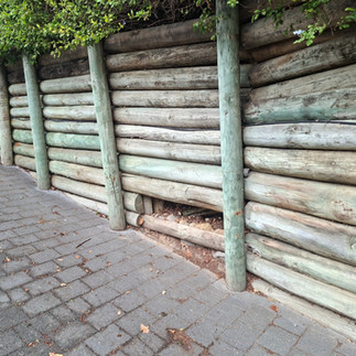 Soil settlement behind a timber retaining wall indicating drainage problems and potential wall failu