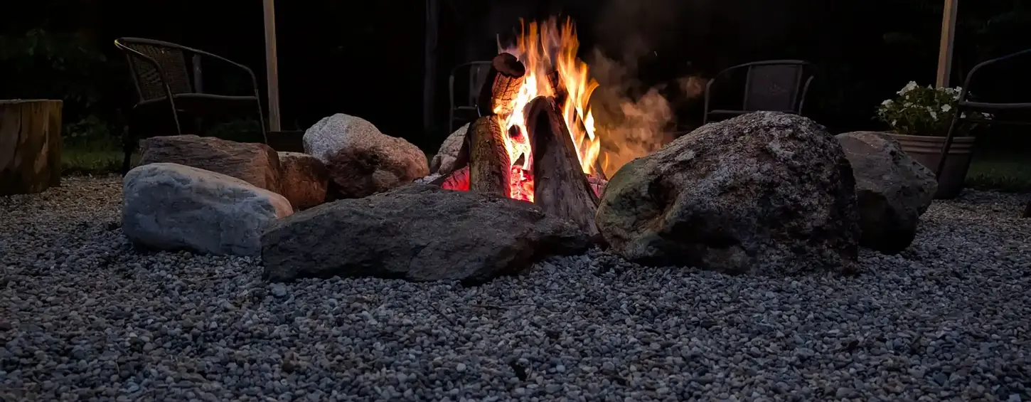 Natural fieldstone fire pit surrounded by a pea-stone seating area in Niles, MI