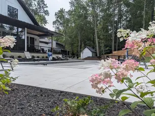 Arcana paver pool deck with pool shed framed by hydrangeas in New Buffalo, MI