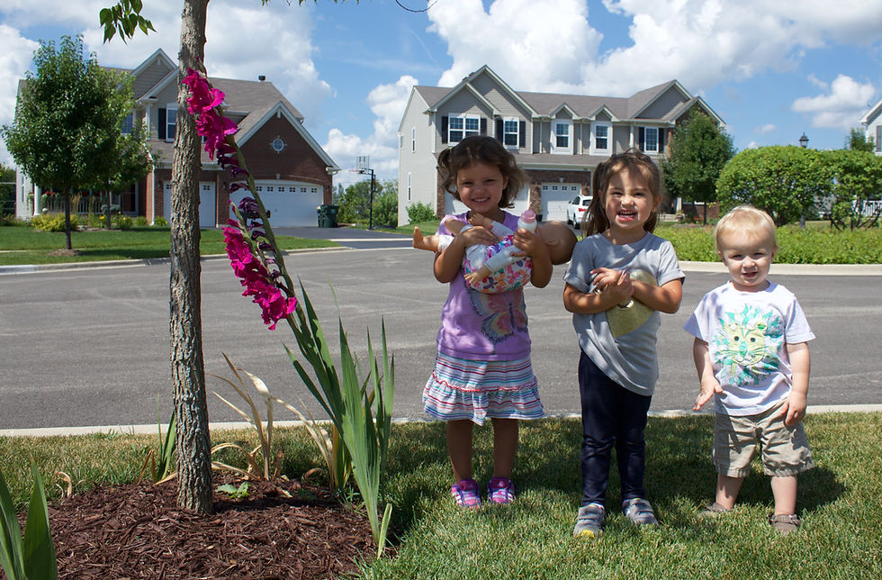 The Blue Sky Daycare home daycare children measure themselves against a tall flower