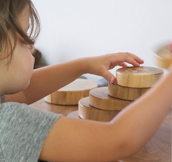 A child playing with handmade nature blocks at Blue Sky Daycare home daycare