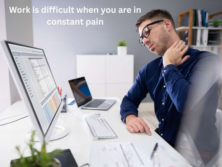 Man at work on computer with a pain in his neck
