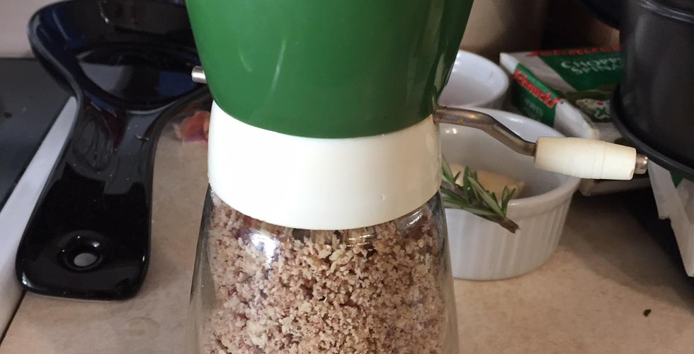Crushed nuts inside the glass resevoir of a nut grinder