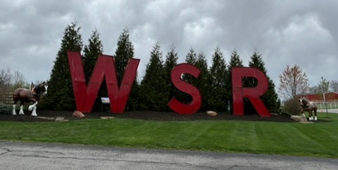Warm Spring Ranch sign with large red W, S, R letters and Clydesdale horse statues on each side