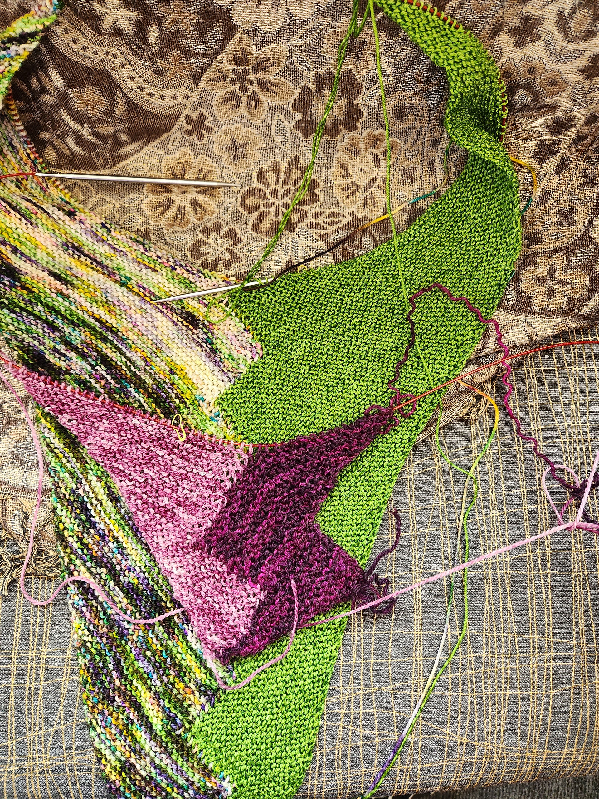 Green knitted shawl and purple with pink knitted shawl projects on circular knitting needles