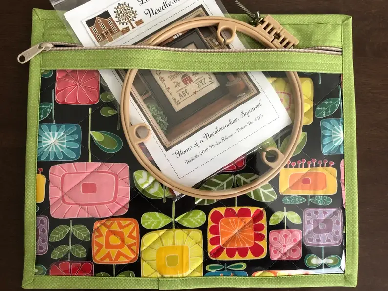 Vinyl-front project bag with cross stitch supplies inside