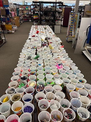 Plastic cups filled with various small items on offer at a cretive reuse center