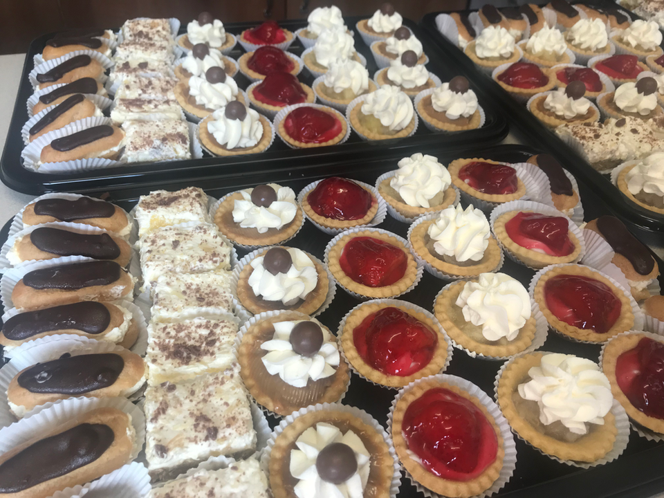 Funeral food table with fine china, sausage rolls, sandwiches and cream pastries – ready for delivery in Lisburn