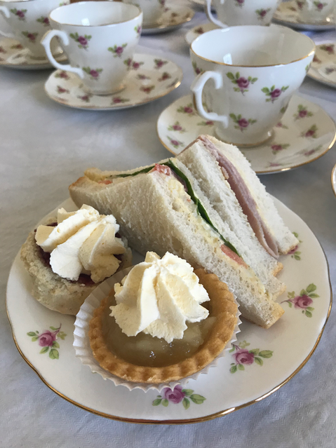 Funeral food table with fine china, sausage rolls, sandwiches and cream pastries – ready for delivery in Lisburn.