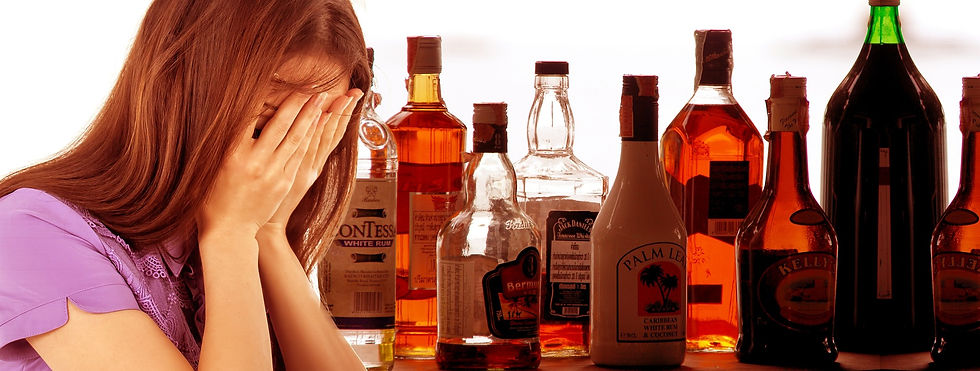 Despairing woman with alcohol bottles