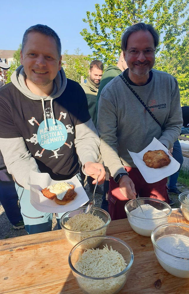 Fred Winkler und Dirk Kreuzer servieren Langos für die Teilnehmer des Männerfestivals Chemnitz 2026.