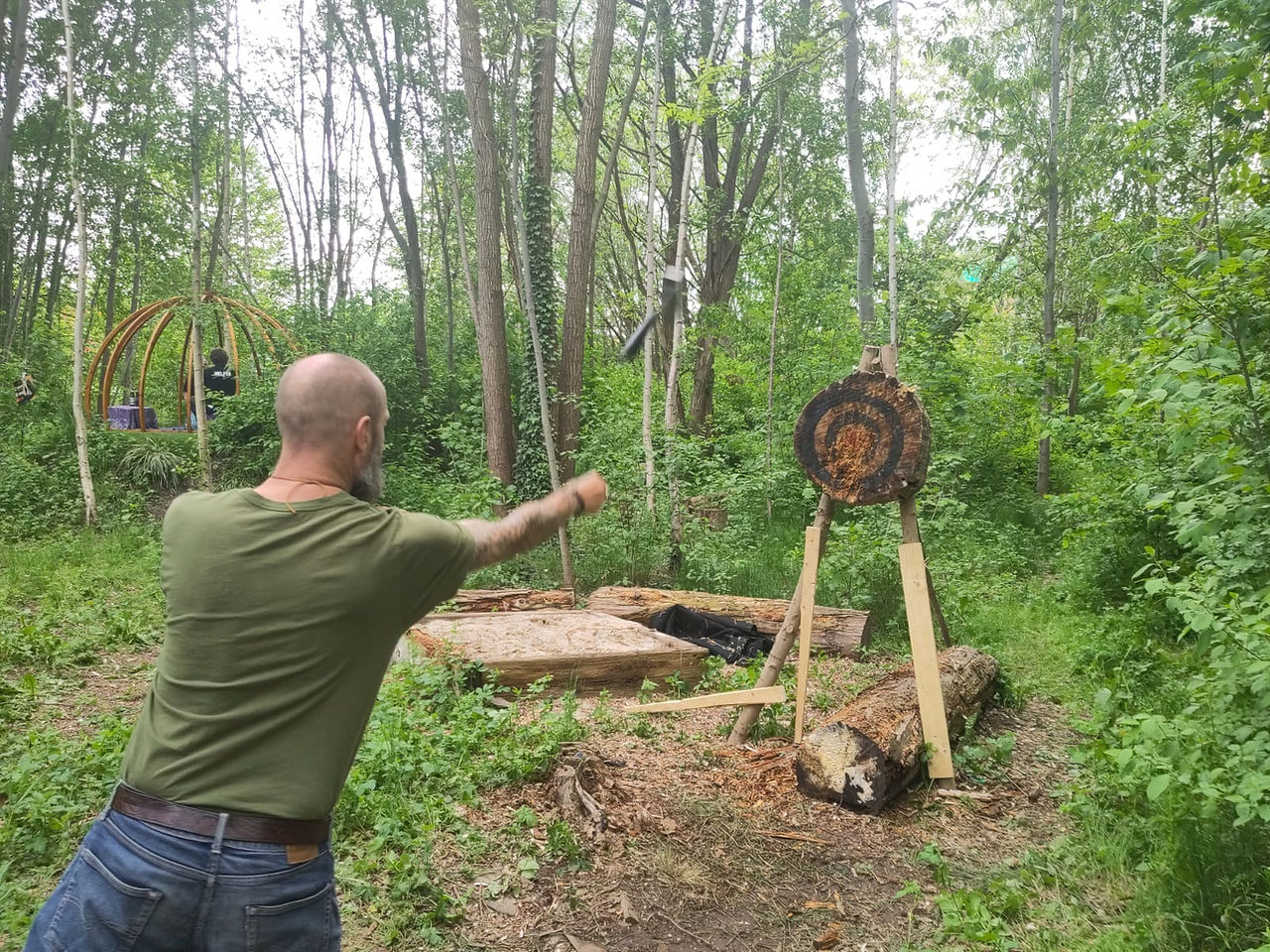 Teilnehmer des Männerfestivals Chemnitz 2026 beim Axtwerfen auf eine Zielscheibe im Wald.