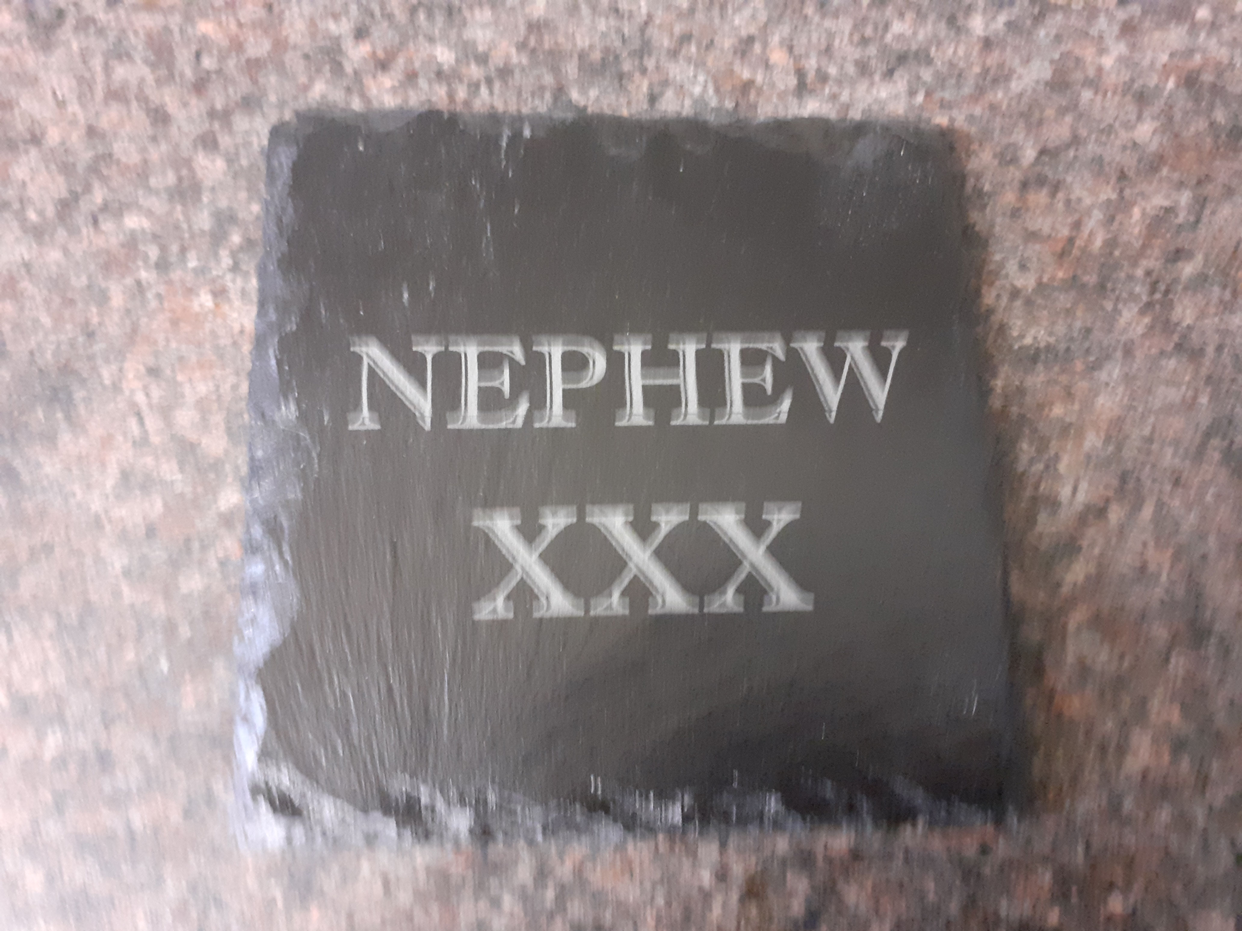 A Natural 4"/10cm Square Slate Coaster with NEPHEW XXX on.