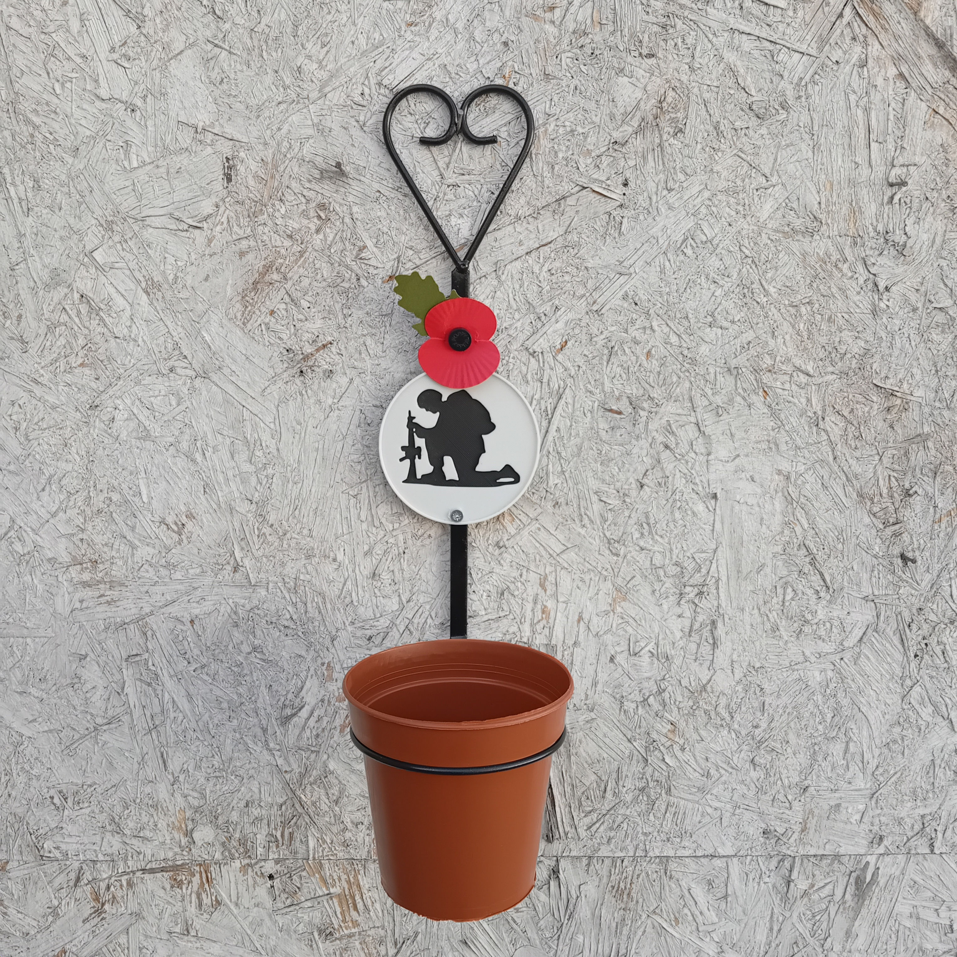 A PLA 8cm Disc of a Kneeling Soldier on a Black Metal 4" Ring Wall Plant Pot.