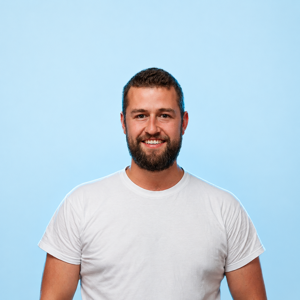Studio portrait of a smiling bearded man in a white t-shirt. Set against a clean, light blue background for a professional touch.