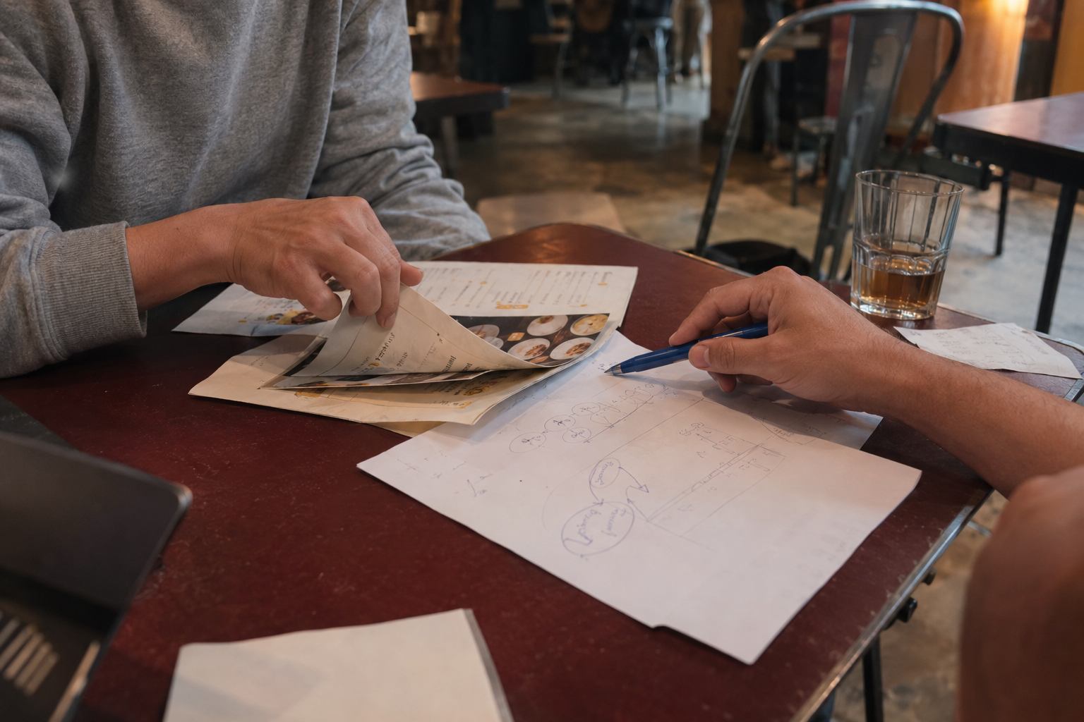 Creative planning conversation with menus and handwritten notes in a cafe