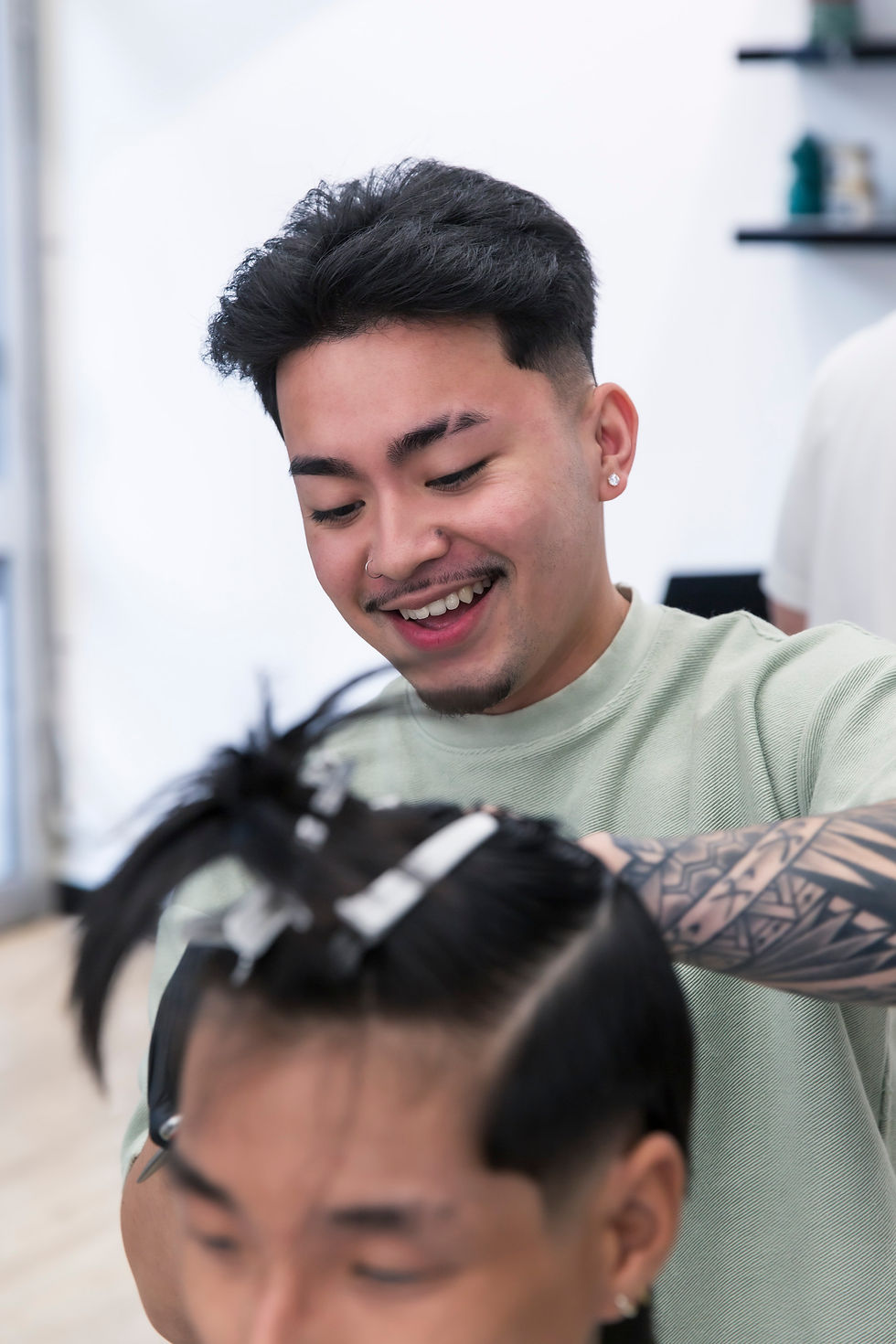 A smiling Ikigai barber working with a client during a haircut