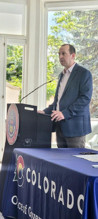 Andy Boesenecker speaking at a bill signing event in Denver, Colorado