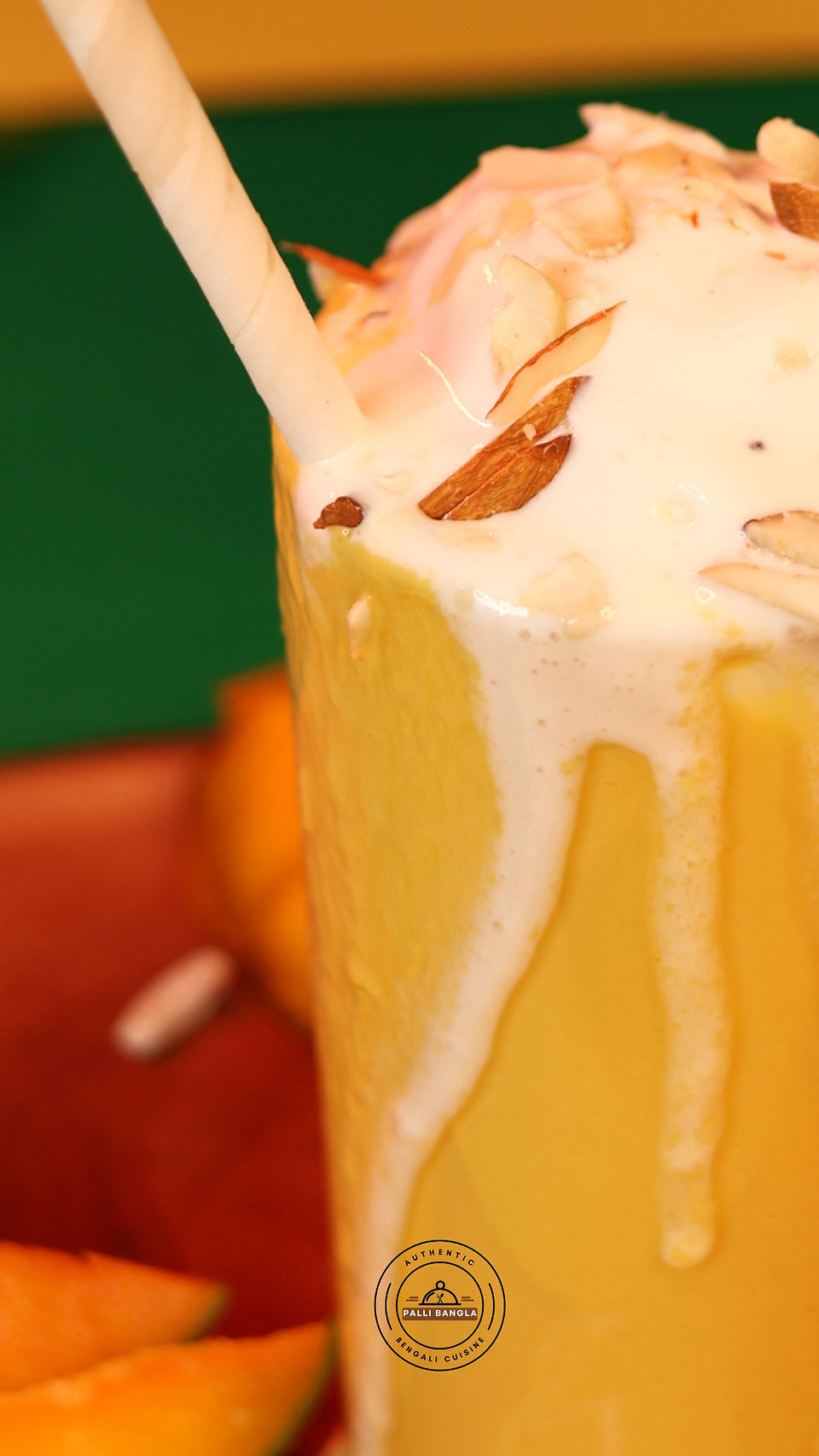 Tall glass of mango shake with ice cream garnish
