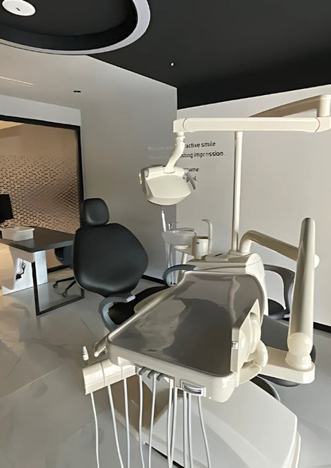 Consultation room in a dental clinic with desk, dental unit, and minimalistic decor.