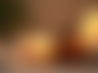 dois frascos com óleos essenciais e velas acesas ao fundo