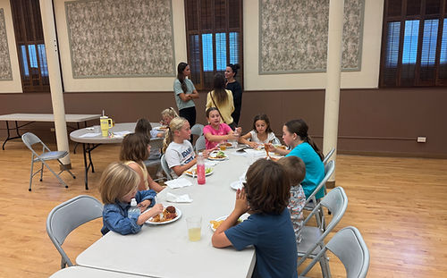 Children sitting around the table enjoying the free Wednesday meal