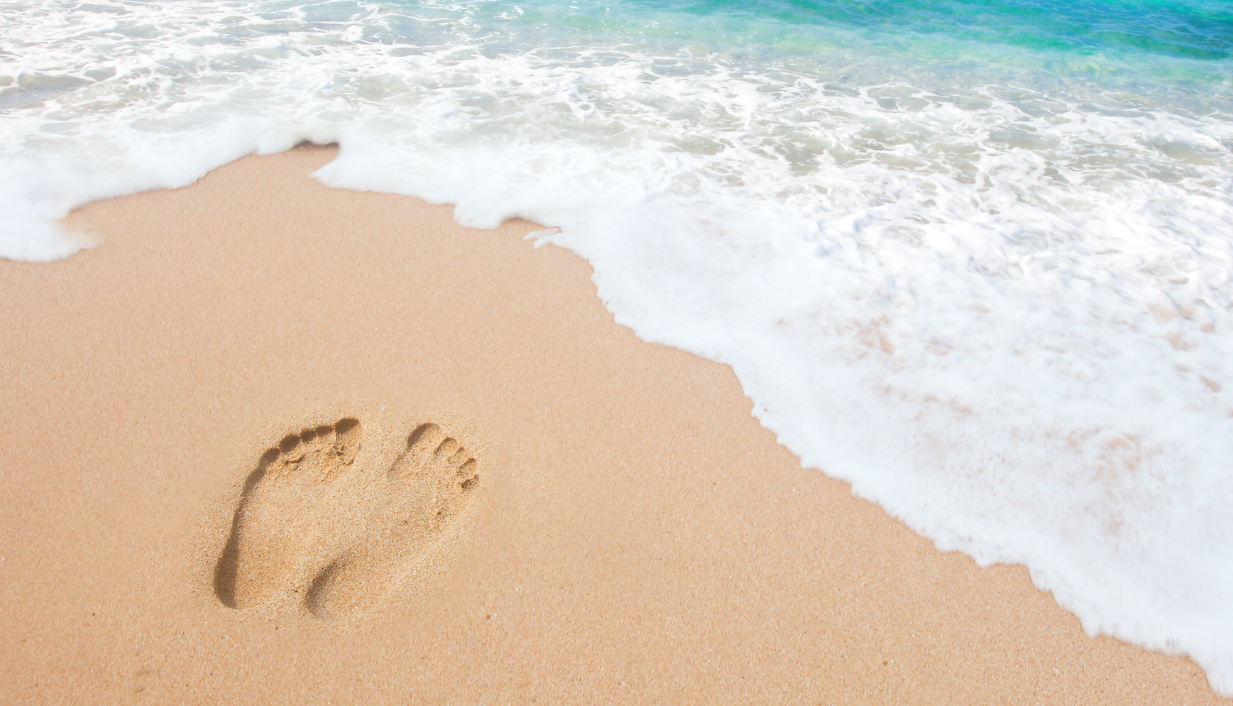 Dirty Feet Yoga with a calming ocean rolling on to a sandy beach with bare feet in the sand.