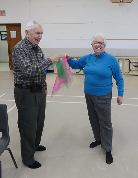 Senior scarf partners enjoying a mobility exercise.