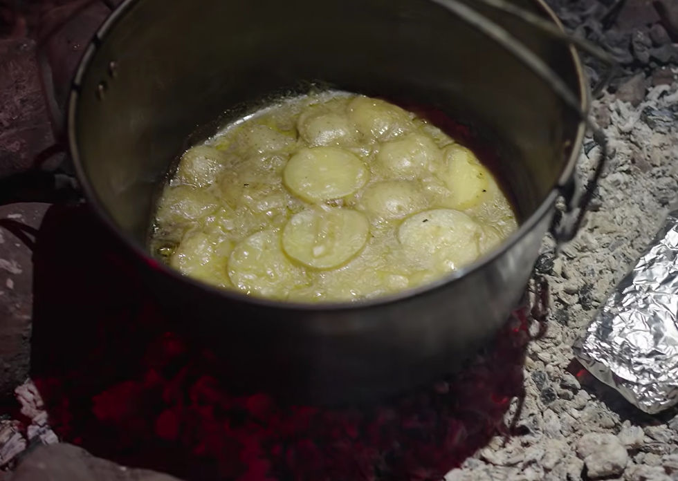 Creamy scalloped potatoes cooking in a camp oven on hot coals, Pannawonica Hill West Pilbara