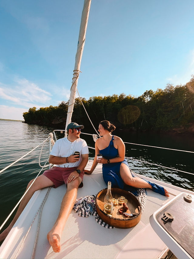 man and woman picnicking on a sailboat