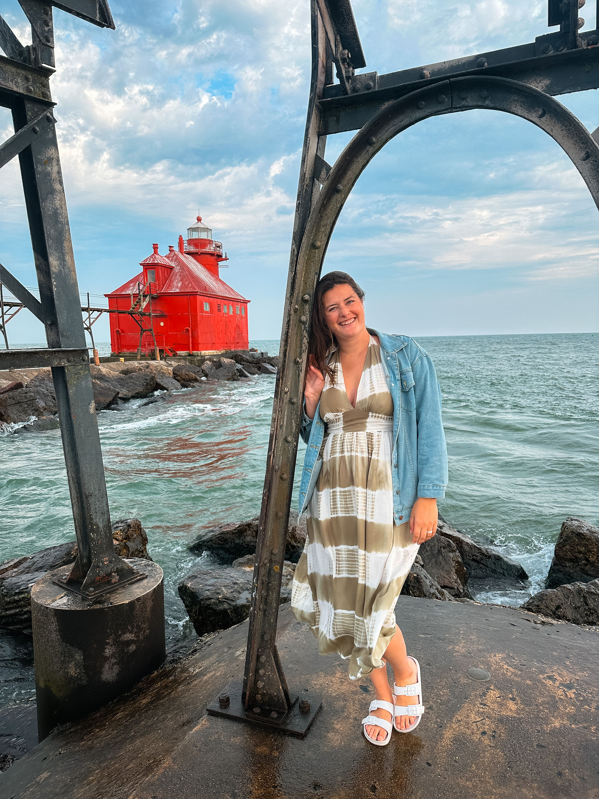 woman standing with red lighthouse behind her