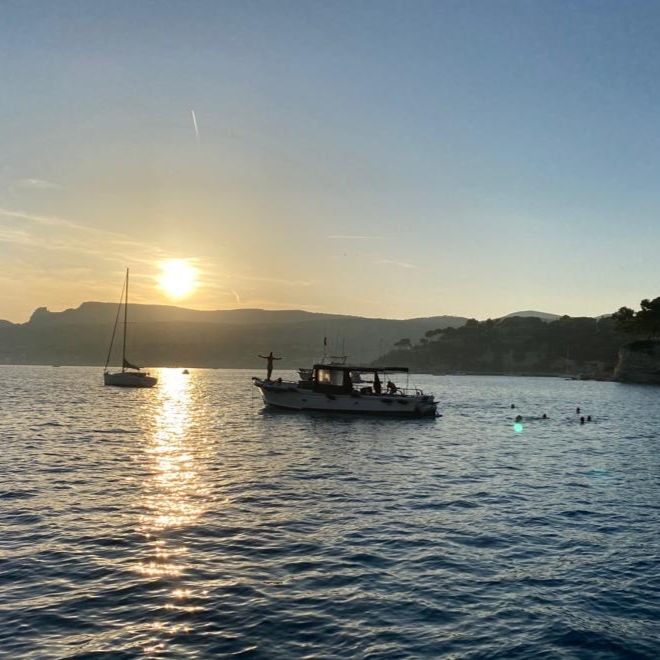 Bateau face au coucher de soleil dans la baie de Cassis