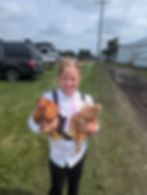 girl holding two chickens smiling