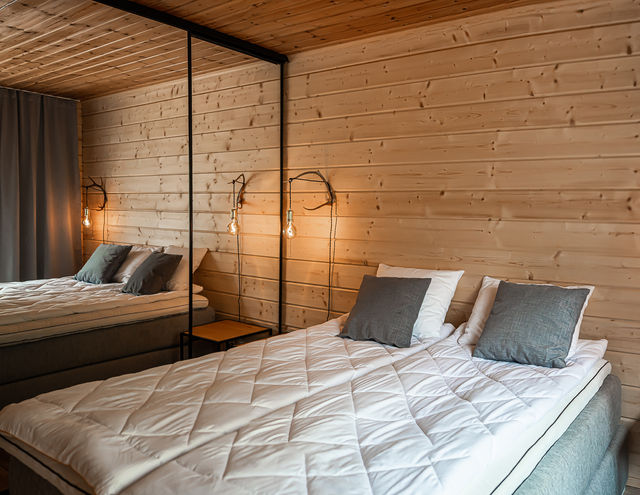 Downstairs bedroom with double bed, mirrored closet, and antler bedside lamp.