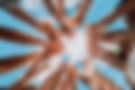 several people reaching up into the sky with their hands in a circle formation