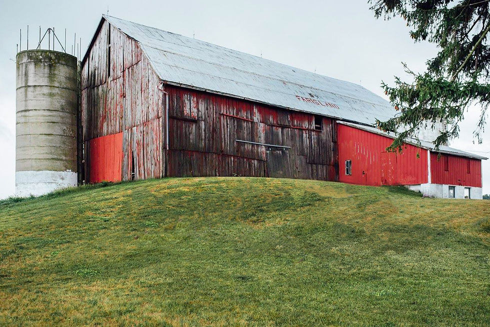 a large weather red barn and partial silo.