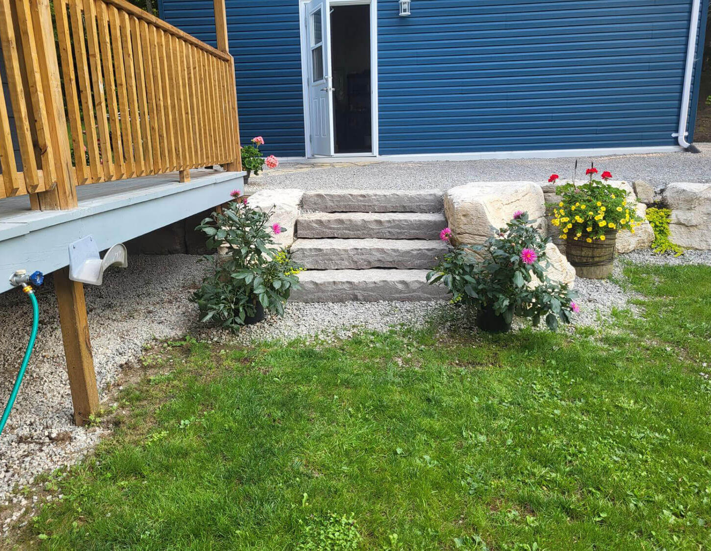 Garden stone steps with flowers and patio blue garage